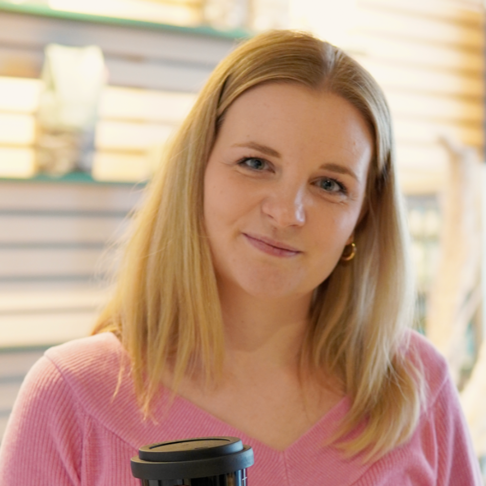 Eine blonde Frau schaut in die Kamera.